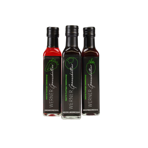 Drei Flaschen Fruchtessig von Werner: Erdbeeressig, Heidelbeeressig und Brombeeressig, präsentiert in eleganten Glasflaschen mit schwarzen Etiketten. Ideal für Salate und kreative Kochrezepte.